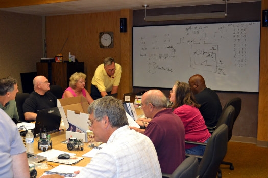 An instructor is helping Teachers Institute participants at a table inside ARRL headquarters.
