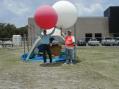 Alan Russell, no call, and Mitchell London, KD5HCV, prepare to launch their 2 helium filled balloons.