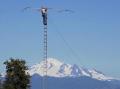 Doyle Bennink, KC7GX climbs top of tower to make adjustment to CW antenna. Mt. Baker in the background. WHAT A VIEW.