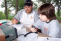 Joseph Hood (12 years old), right, is introduced to Field Day by Jason Campbell (KG4WGB), member of the Radio Amateur Club of Knoxville in TN.