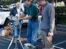 The testing team down in the parking lot with a rig for testing and the measurement gear. Kerry Banke, N6IZW, adjusts the receiving antenna system while Dave Hartzell, AF6KD, looks on. 