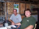 Picture of Réal VE2GB in the background and André VE2AC in the foreground in Réal's small shack behing his house.  