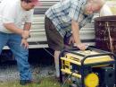 Eric Weber (KC0AHK) prepares to pull the starting rope on the generator as Glen Felt (WT0A) holds it down. 