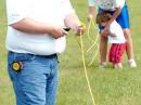 Eric Weber (KC0AHK) and his children, Natalie and Jonathan, made a family affair out of Field Day setup as the kids help Eric measure and cut lengths of guy rope for the push-up towers.