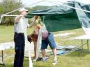 Jake Colgrove (KB0WXS) and Andrew Templeton (KC0UPF) attempt to assemble the tent beneath which the operators will sit.