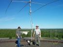 Looking east, Rene, VA3RFD and Steve VE3CWJ at CW/Phone station beam setup. Beam is TH3jr, about 50 ft up. In photo, from left to right...
1) Rene, VA3RFD
2) White silo holding CW station beam
3)in background below us all, the Sudbury Airport
4)TH3jr beam
5) just to right of beam mast, boom truck boom holding wire antennas...
6) Steve VE3CWJ

hi hi our wire antennas are higher than the airport...
