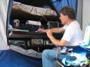 Dennis operates out of a truck tent behind the Taco Ma, running a cable through the camper shell and using the tailgate for a desk. The 11-year-old laptop at right is running PSK 31 (whatever that is).
